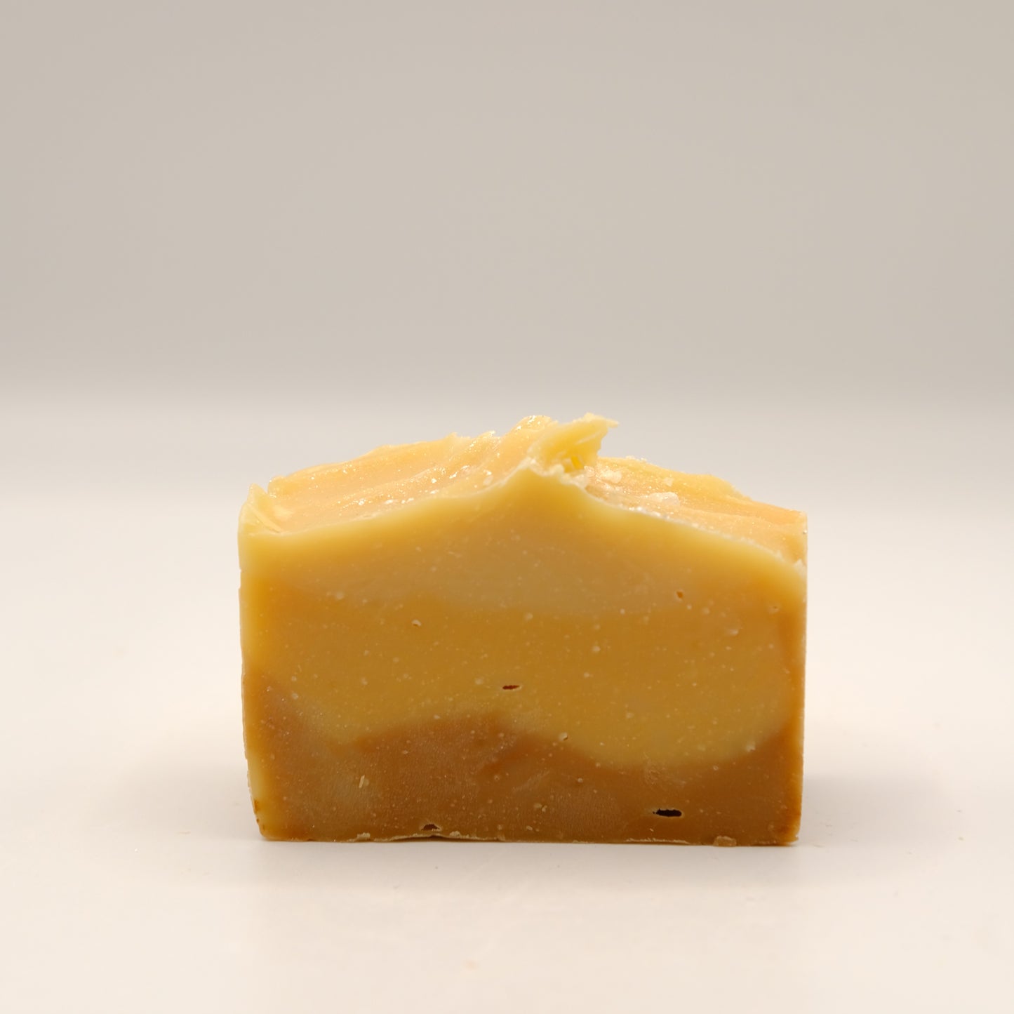 Yellow soap bar on a light gray background