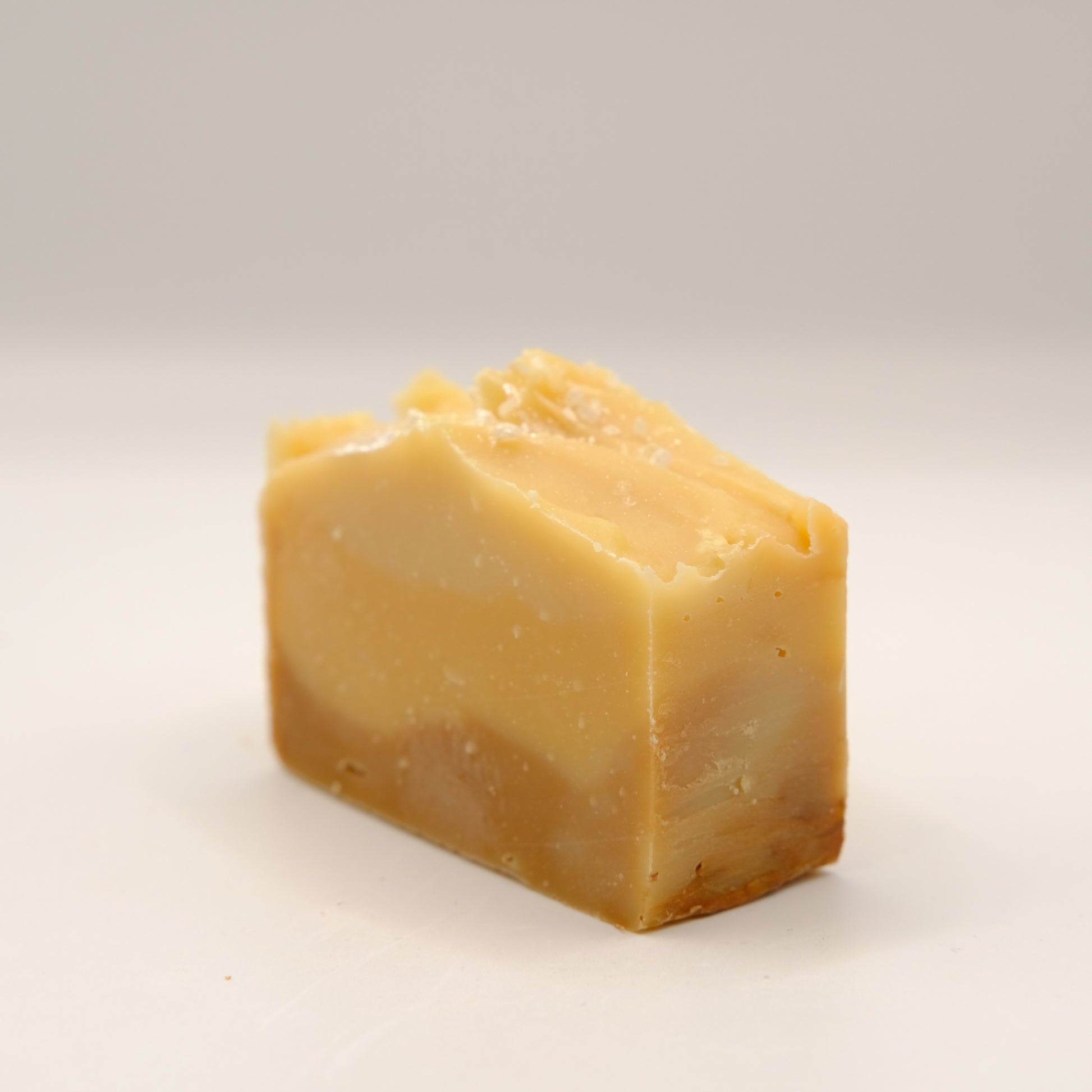 Block of yellow soap on a light gray background