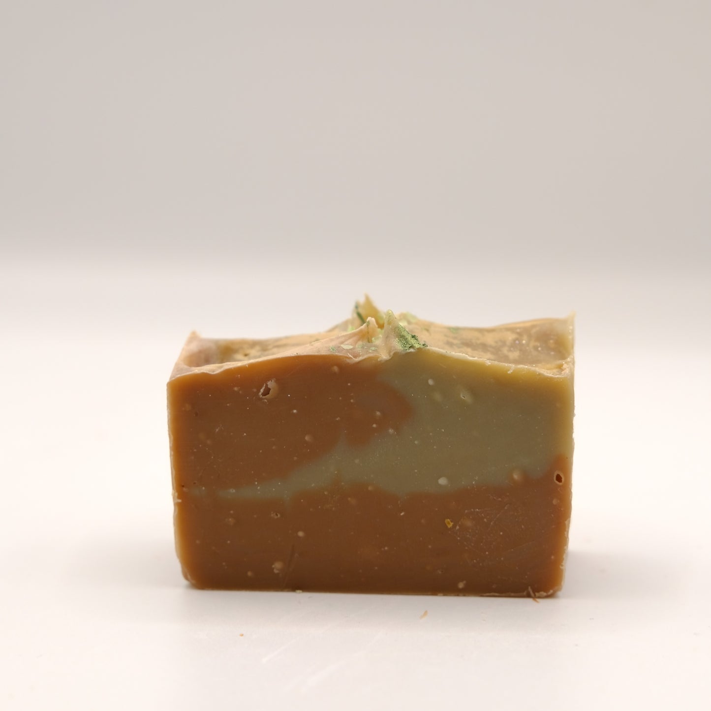 Bar of soap with a natural, slightly rough texture on a white background