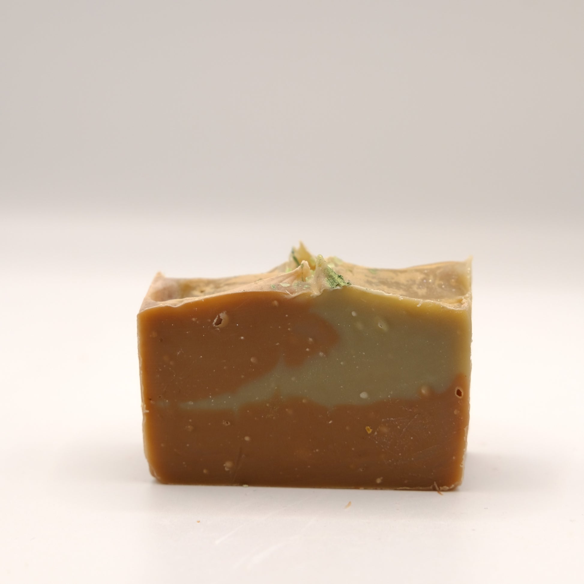 Bar of soap with a natural, slightly rough texture on a white background