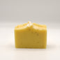 Yellow soap bar with specks on a white background