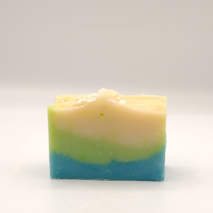 Three-layered soap bar with green, beige, and blue colors on a white background