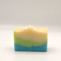 Three-layered soap bar with green, beige, and blue colors on a white background