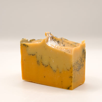 Block of yellow soap bar with specks on a white background