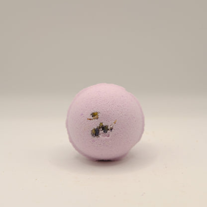 Purple bath bomb with decorative elements on a beige background