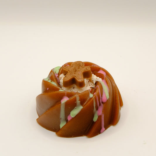 Cake-shaped soap with a gingerbread man decoration on a light background