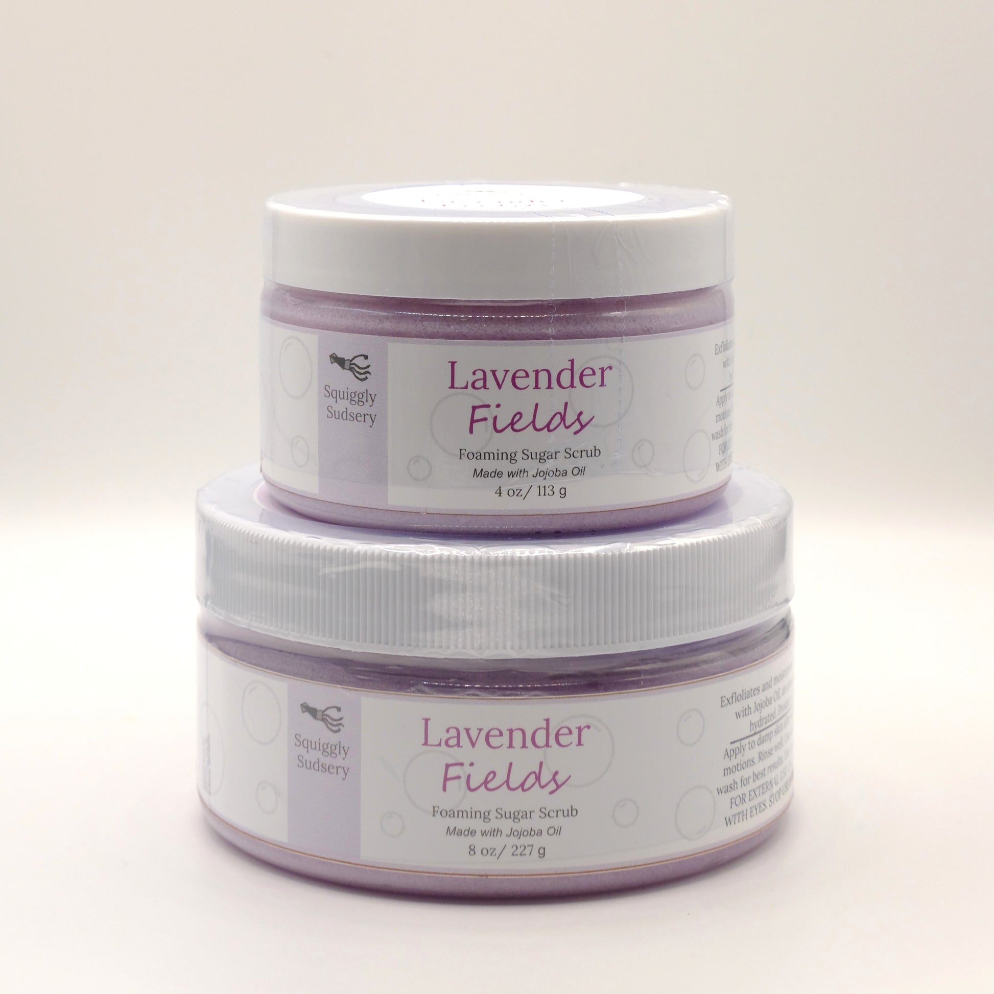 Two stacked jars of Lavender Fields Foaming Sugar Scrub on a light background