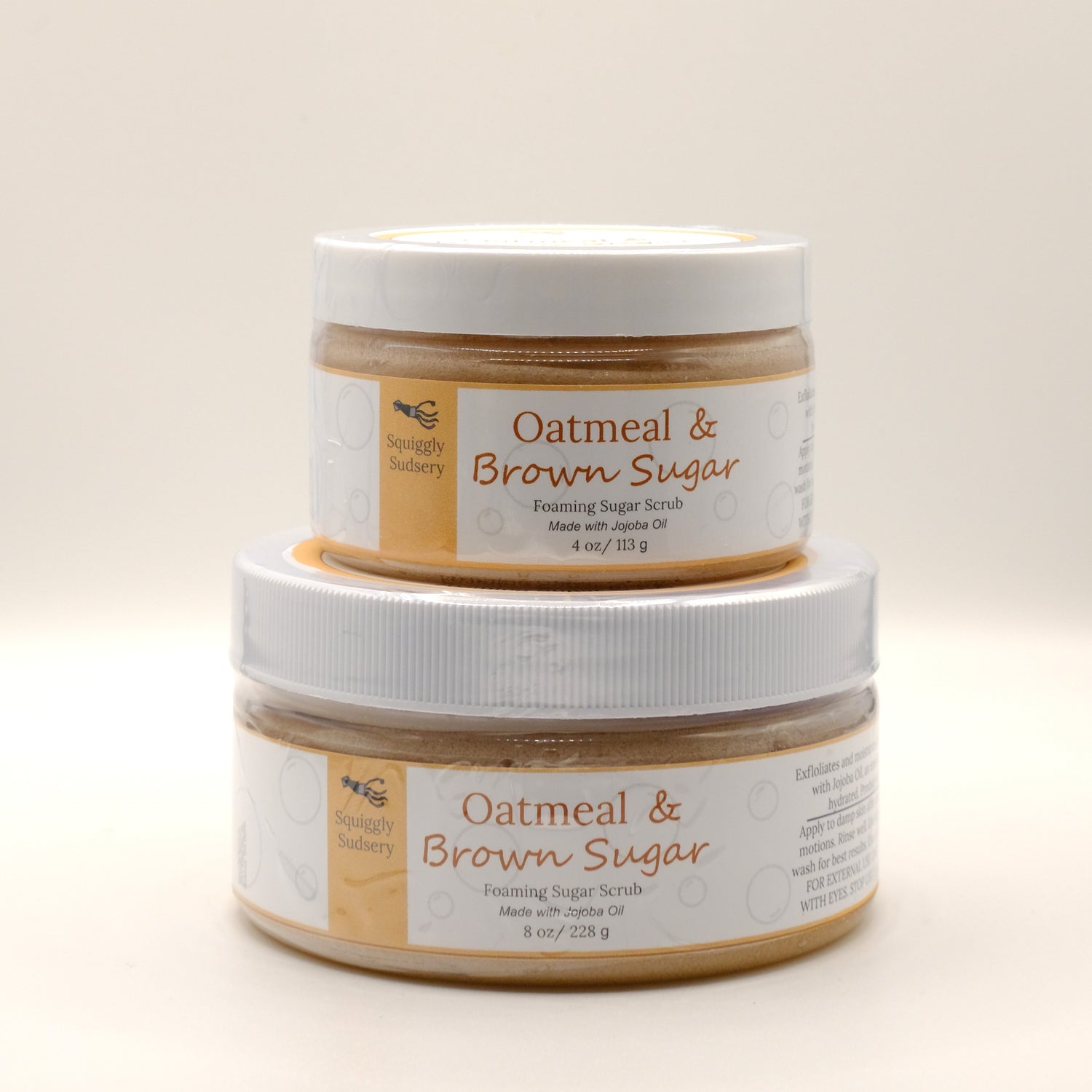 Two stacked jars of Oatmeal & Brown Sugar Foaming Sugar Scrub on a light background