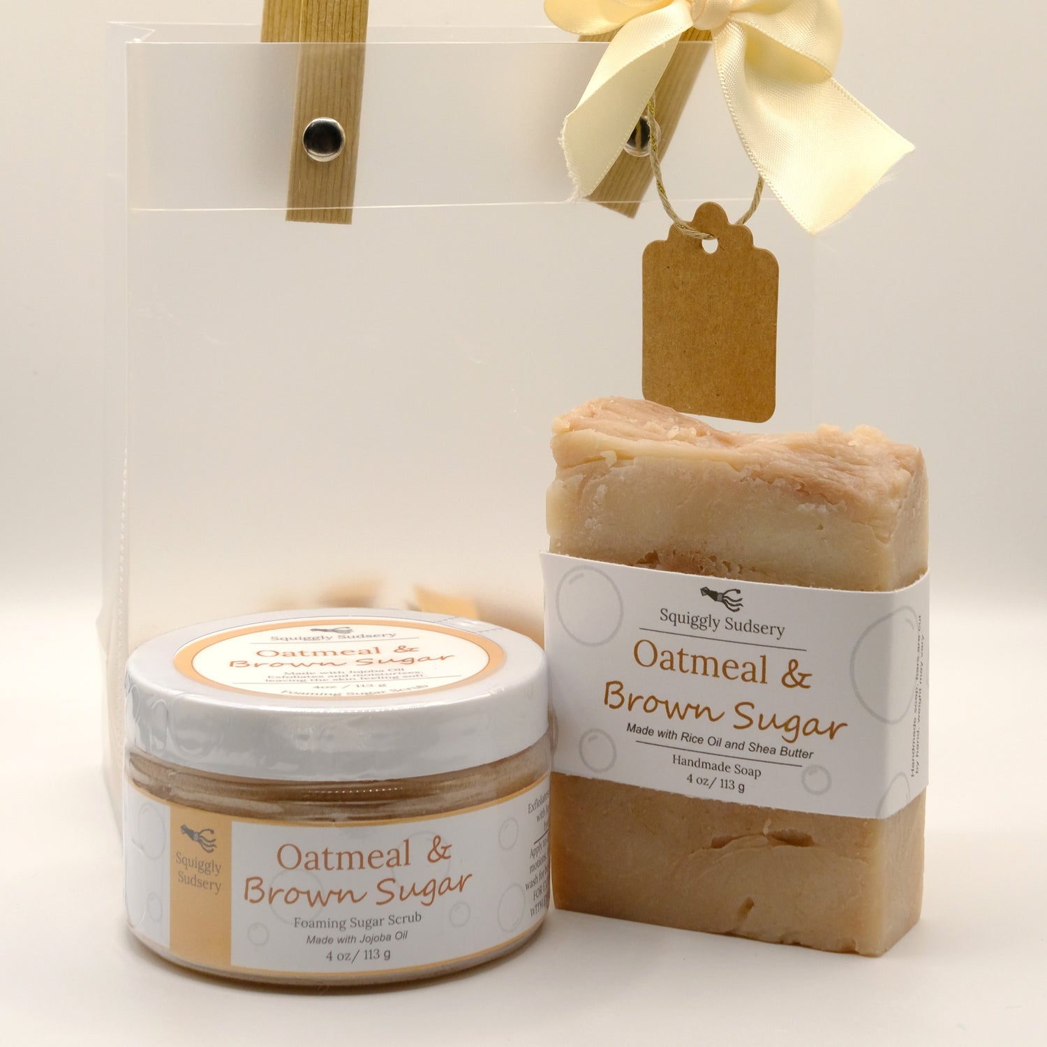 Oatmeal & Brown Sugar soap and jar of foaming sugar scrub with gift bag in the back, all on a white background
