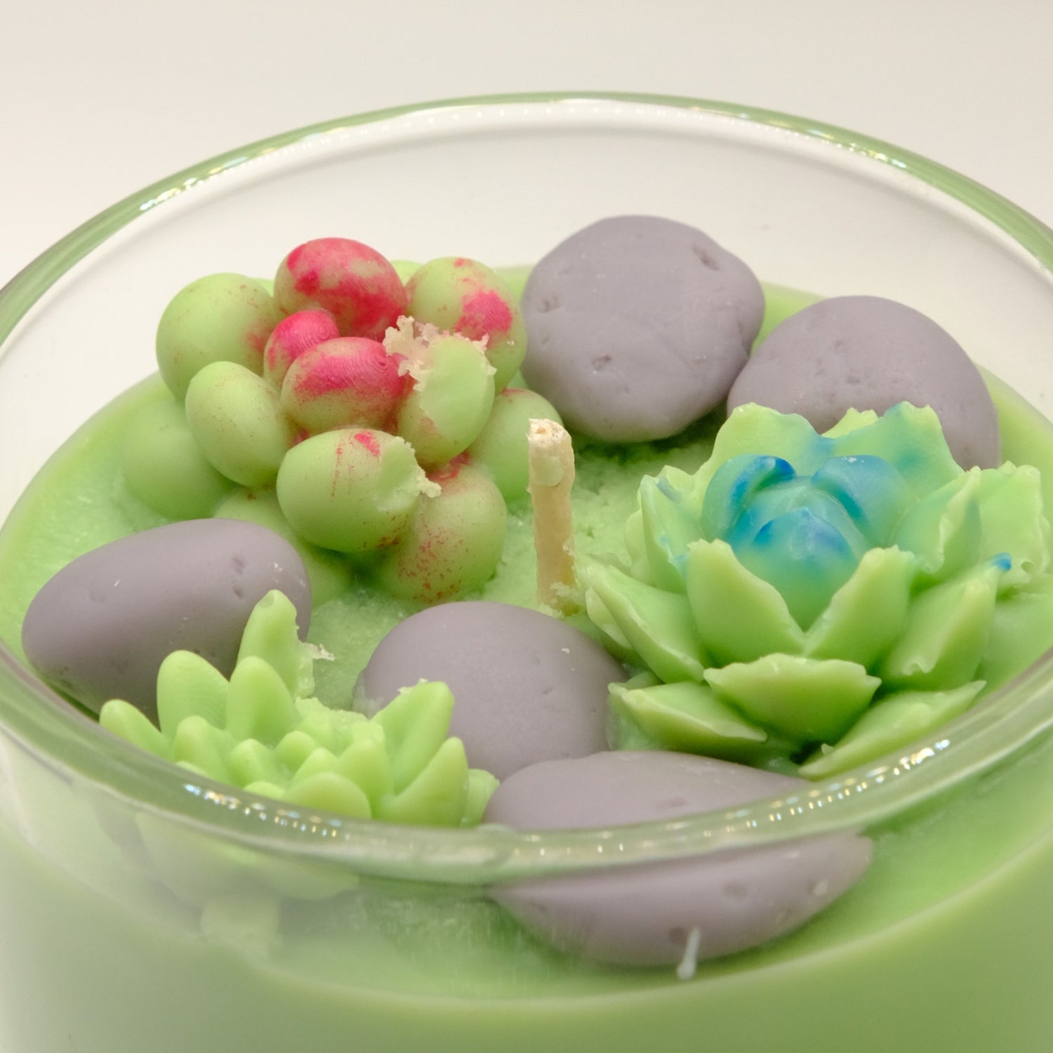 Decorative candle with succulent designs in a glass container