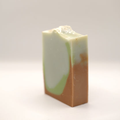 Rectangular bar of soap with a gradient from green to brown on a white background
