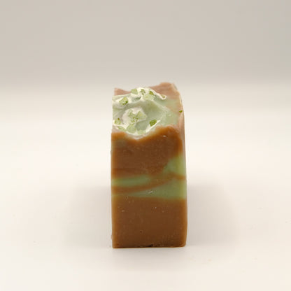 Bar of soap with green and brown swirled pattern on a light background