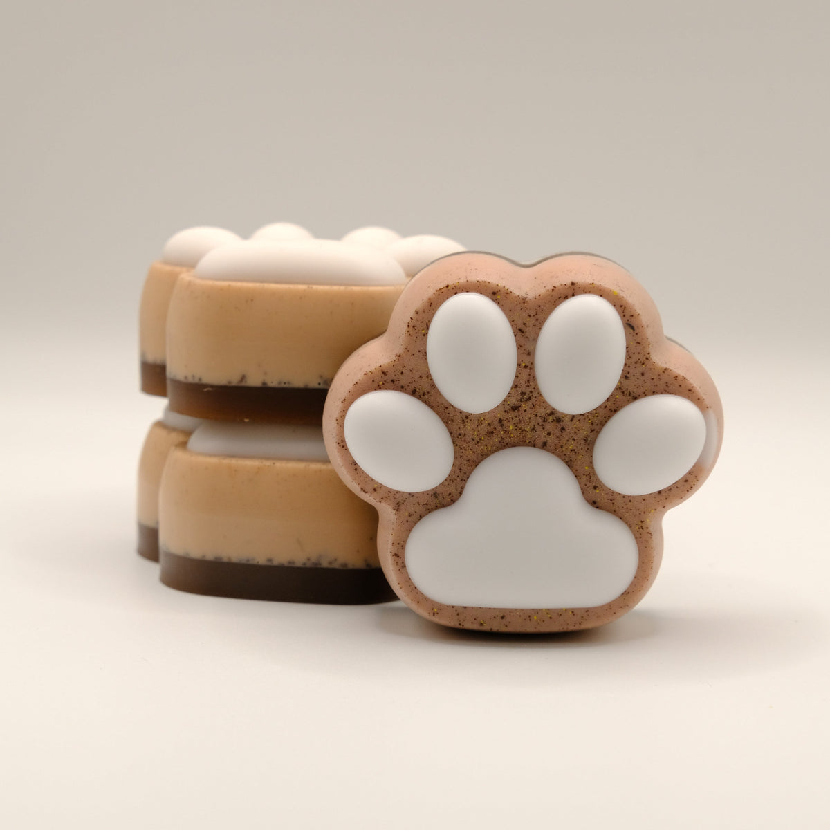 Three soap bars with paw print design on a light background