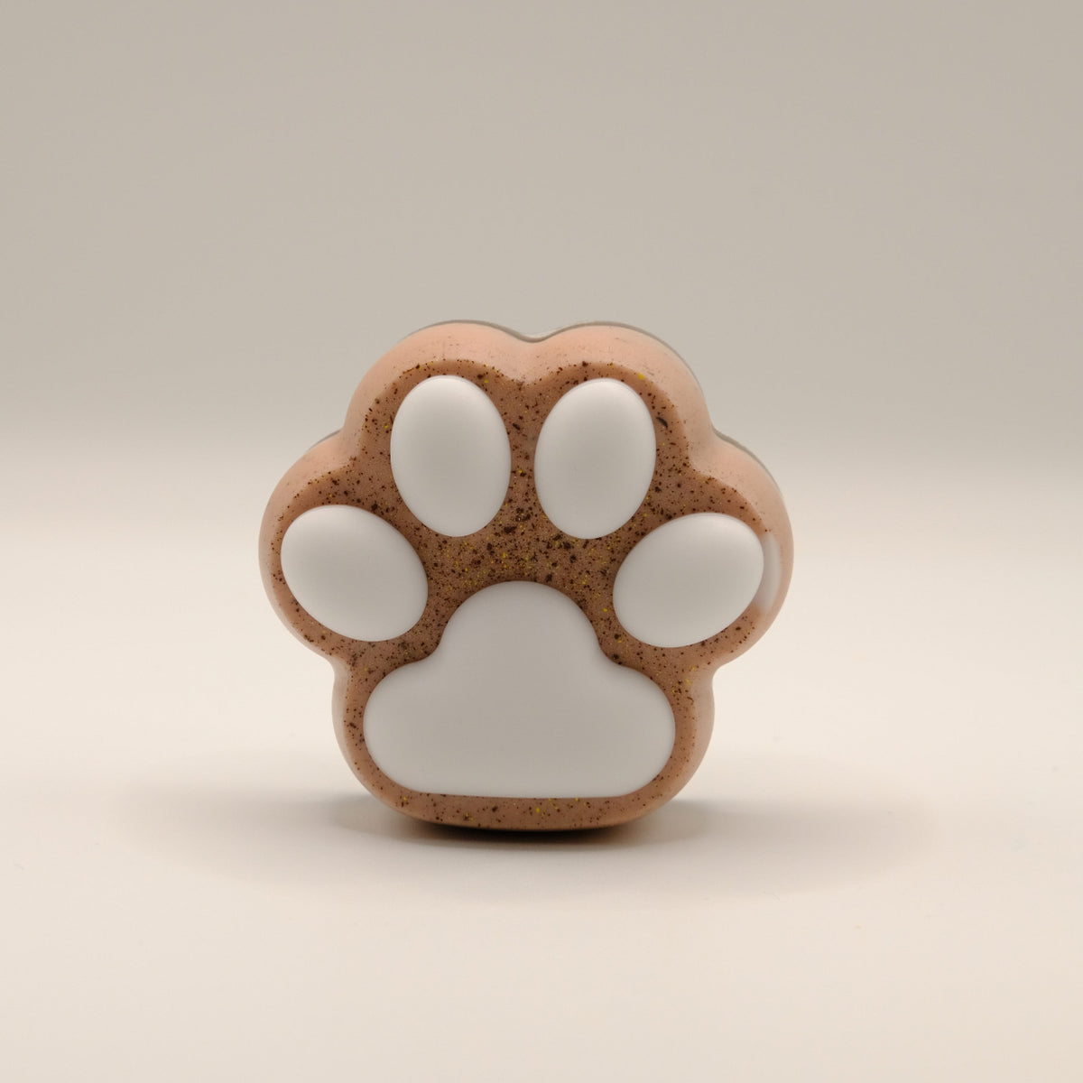 Brown soap bar shaped like a paw print on a beige background