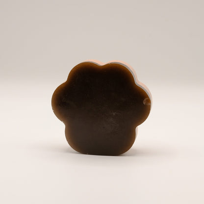 Brown soap bar shaped like a paw print on a beige background