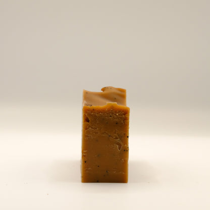Bar of brown soap on a light beige background