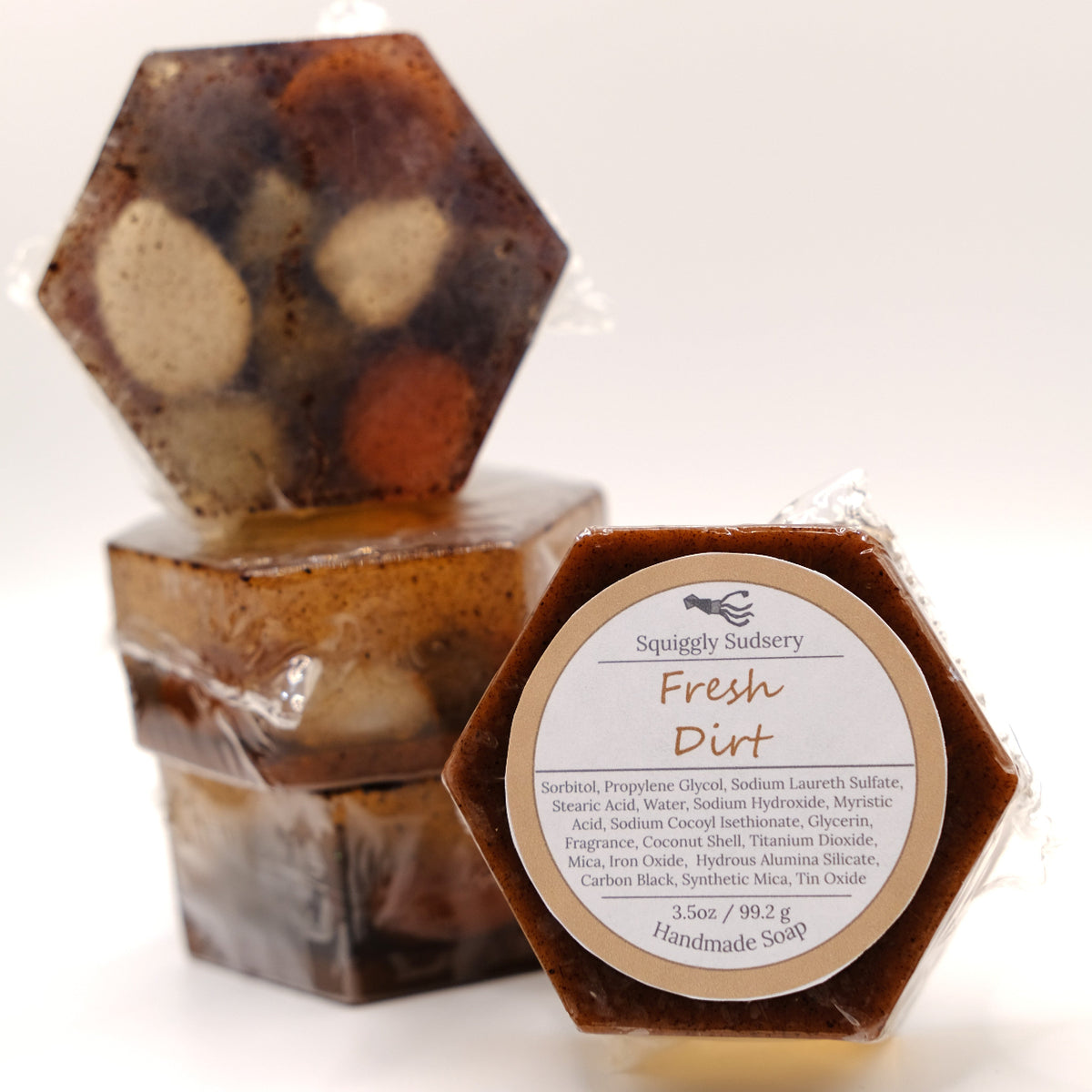 Hexagonal handmade soap with rocks inside and a label on a white background