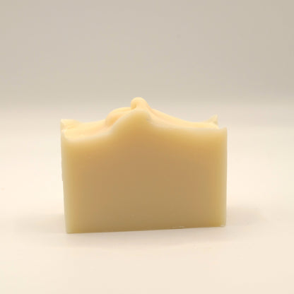 Beige soap bar with a textured top on a light beige background
