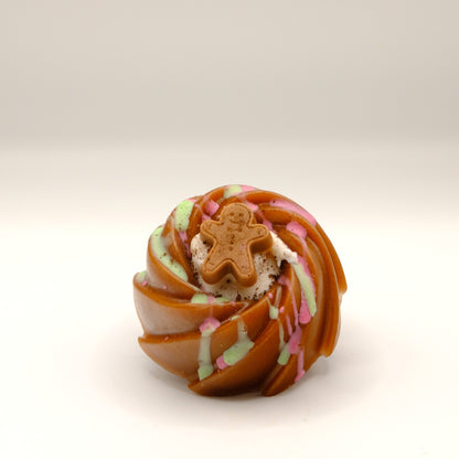 Cake-shaped soap with a gingerbread man decoration on a light background