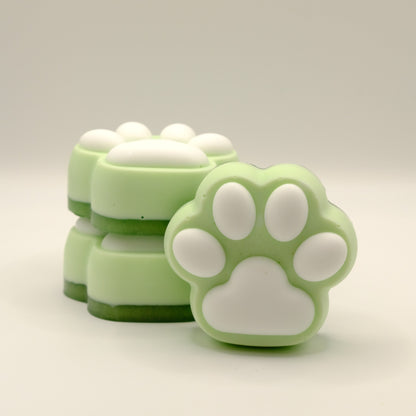 Green and white soap bars with a paw print design on a light gray background