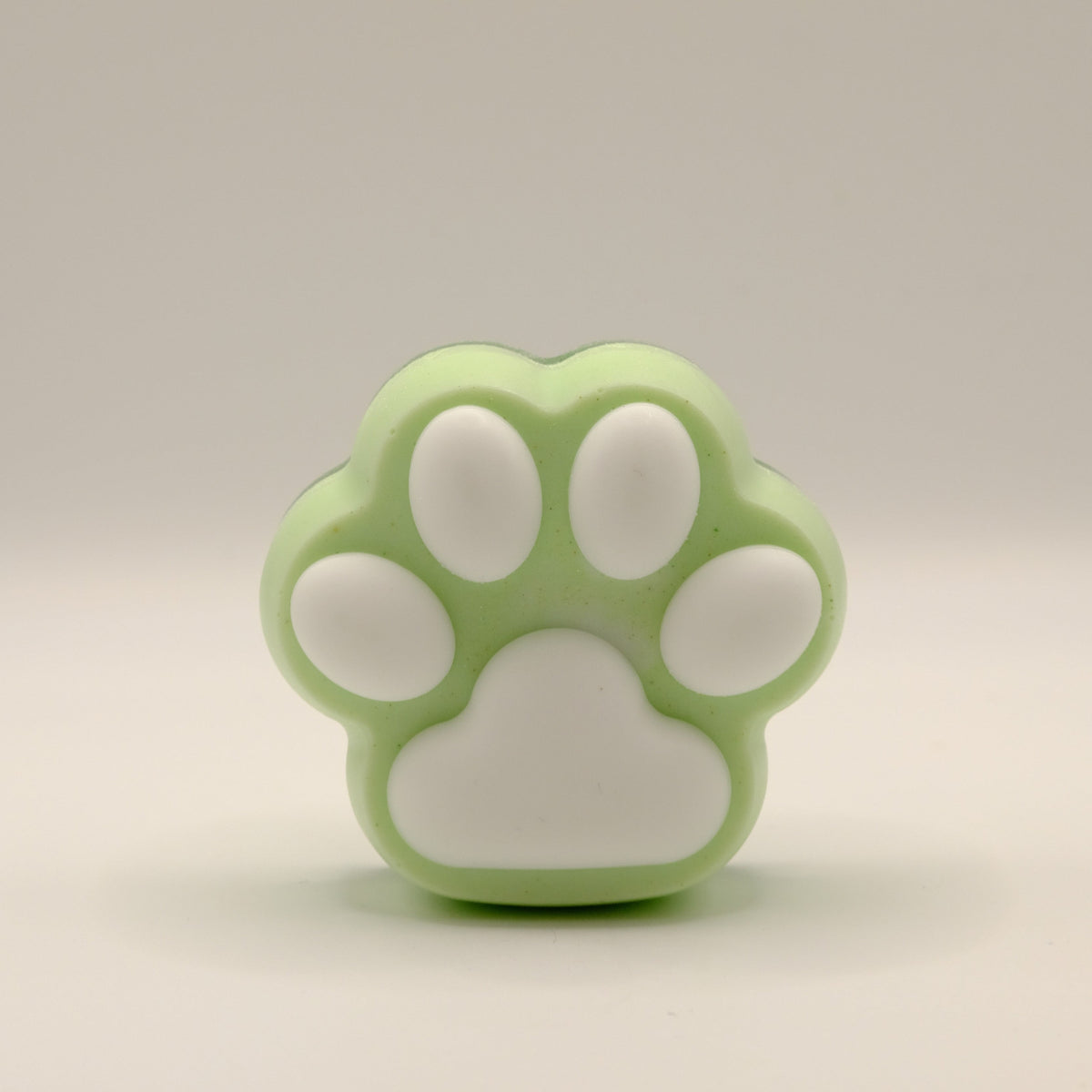 Green and white soap bar with a paw print design on a light gray background