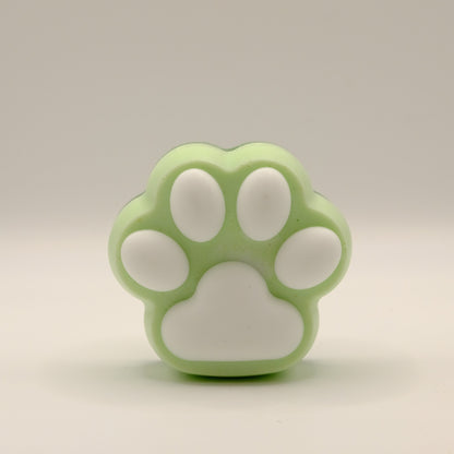 Green and white soap bar with a paw print design on a light gray background