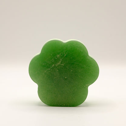 Green soap bar with a paw print design on a light gray background