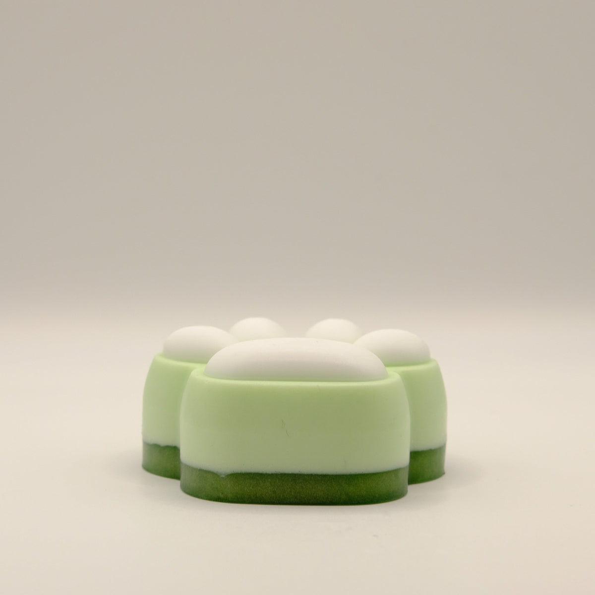 Green and white soap bar with a paw print design on a light gray background