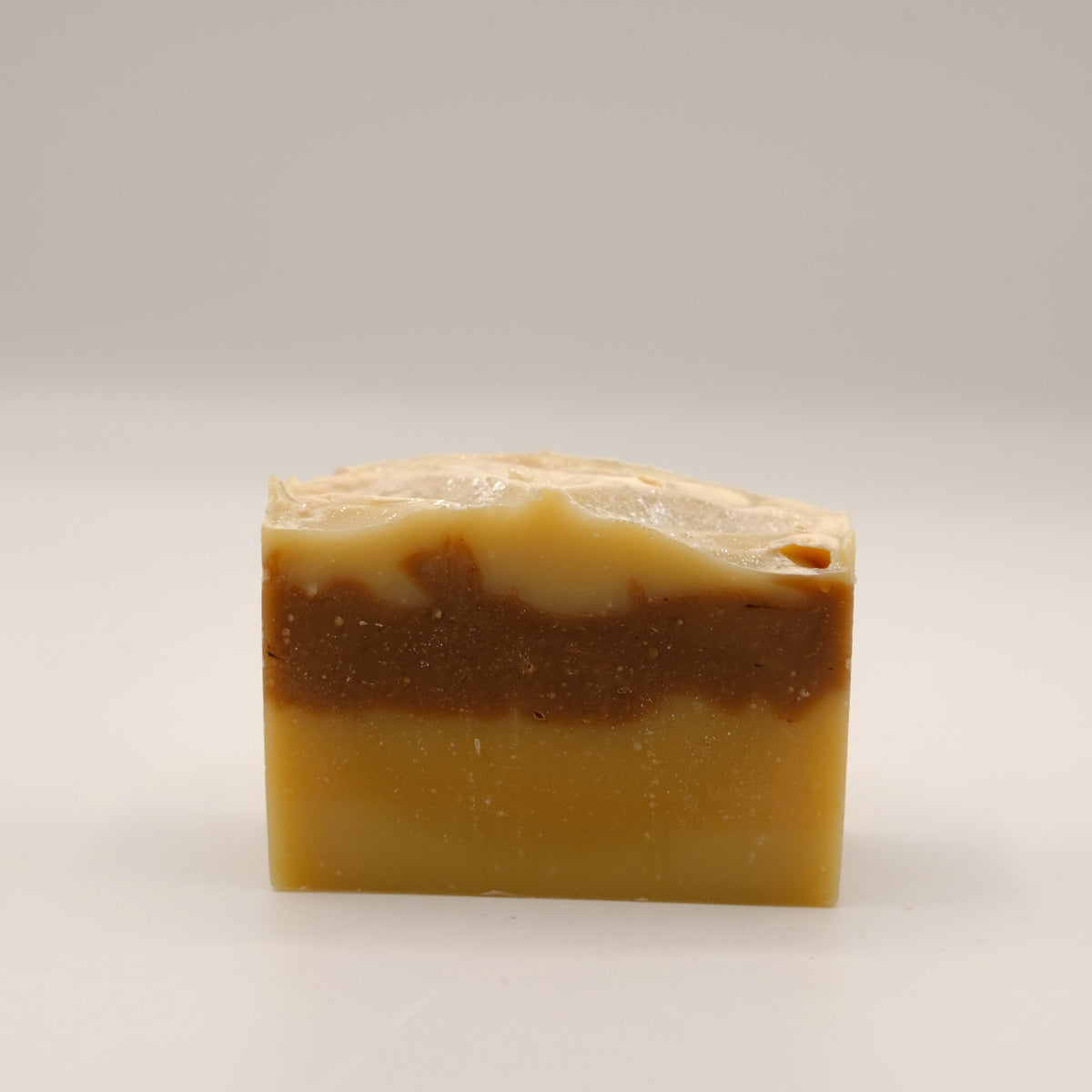 Bar of brown and beige soap on a light gray background