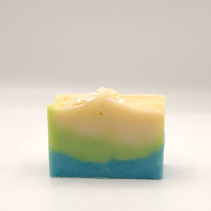 Three-layered soap bar with green, beige, and blue colors on a white background