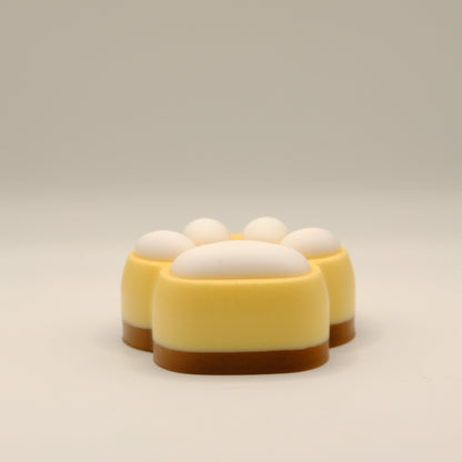 Brown, yellow and white soap bar with a paw print design on a light gray background