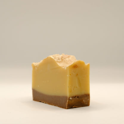 Bar of soap with a yellow and brown two-tone color on a light gray background