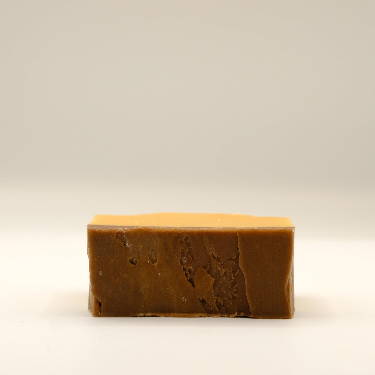 Bar of brown soap on a beige background