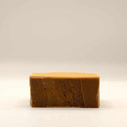 Bar of brown soap on a beige background