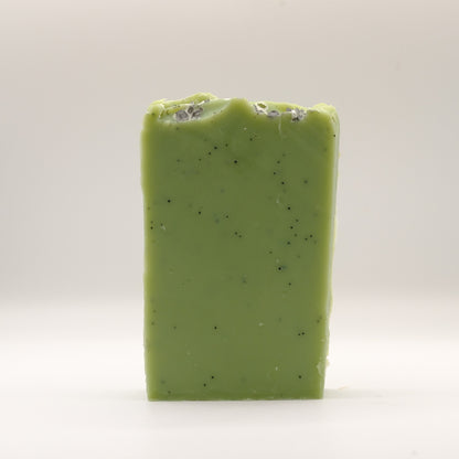 Green soap bar with specks on a white background