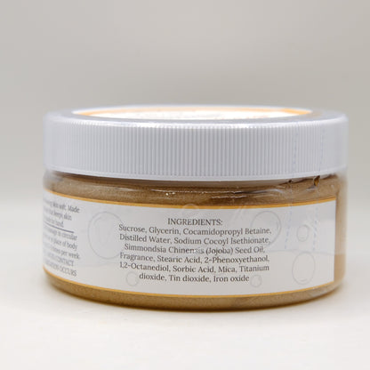Jar of brown sugar scrub with a white label on a light gray background