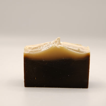 Bar of soap with a two-tone brown and beige color on a light gray background