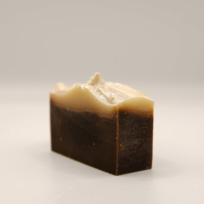 Dark brown soap bar with beige top on a white background