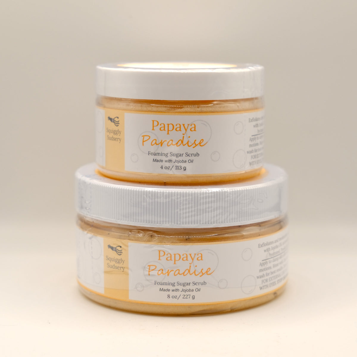 Two jars of Papaya Paradise foaming sugar scrub on a light background