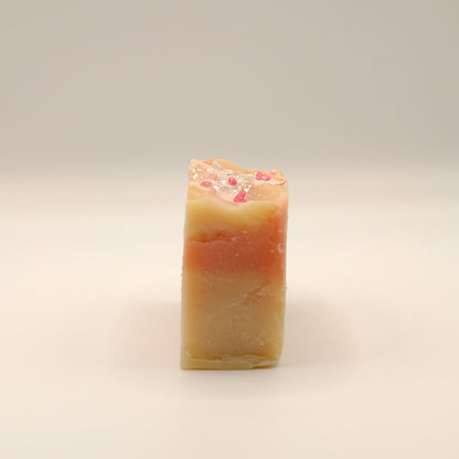 Beige and red bar of soap on a light background.
