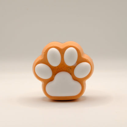 Orange and white paw-shaped soap bar on a beige background