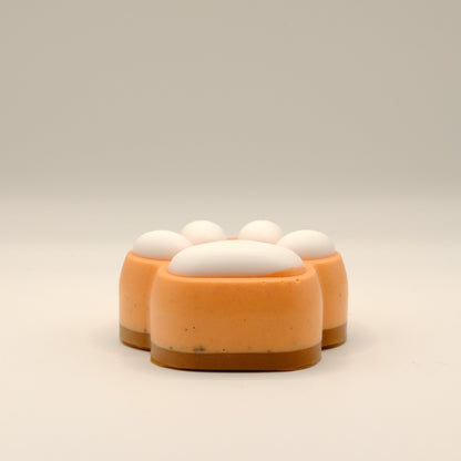 Orange, brown and white paw-shaped soap bar on a beige background