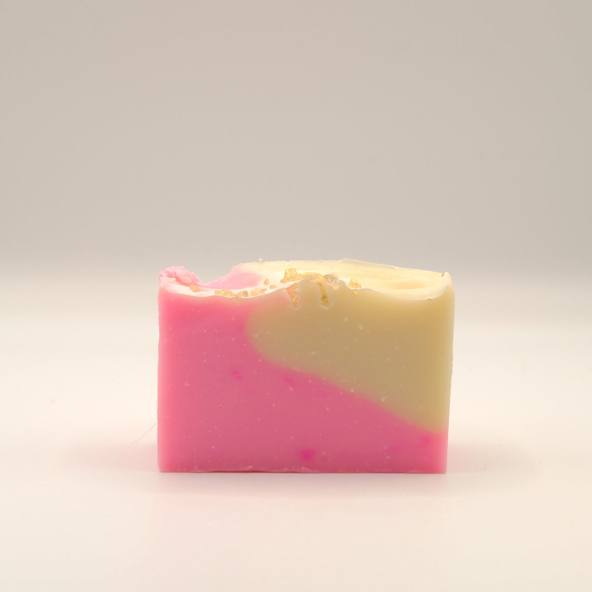 Two-tone pink and beige soap bar on a light background