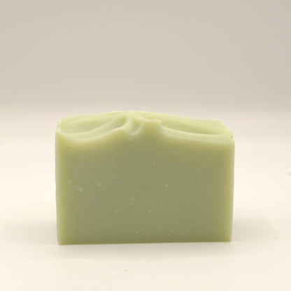 Green bar of soap with a textured top on a light background