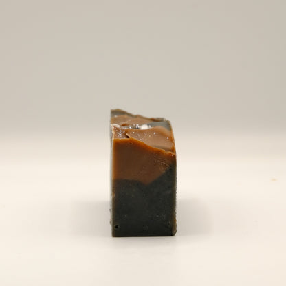 Two-tone brown soap bar on a light beige background