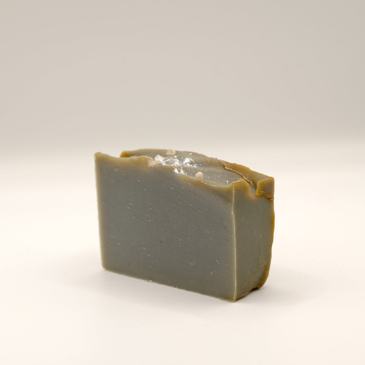 Grey bar of soap with a textured surface on a light background