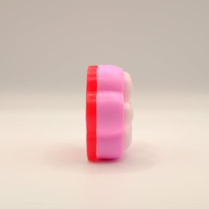 Pink, white and red soap bar with a paw print design on a beige background