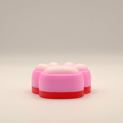 Pink, white and red soap bar with a paw print design on a beige background