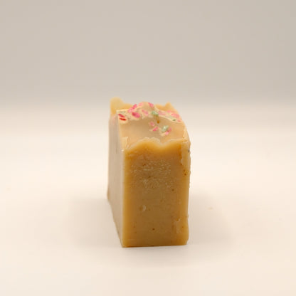 Light brown bar of soap with a textured surface on a light background.