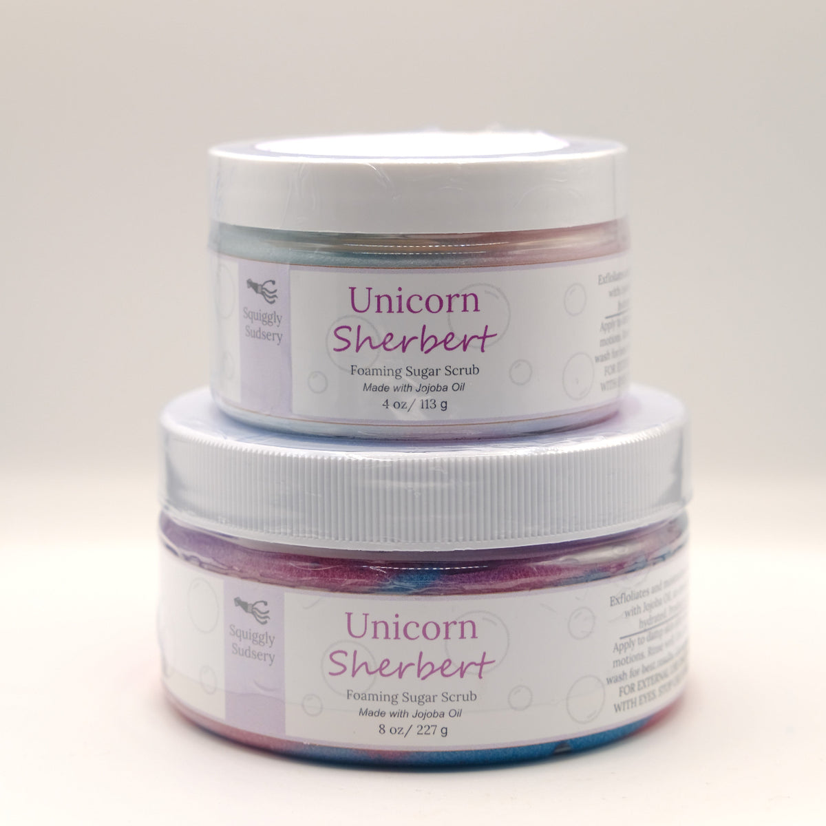 Two jars of Unicorn Sherbert foaming sugar scrub on a white background